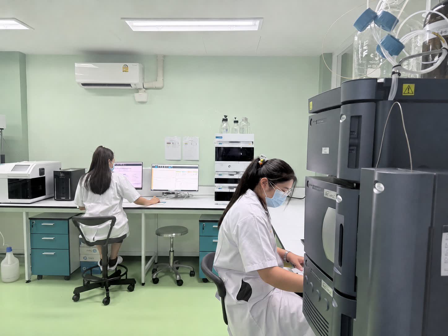Analysts reviewing analytical data and preparing samples in the laboratory